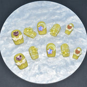 square-shaped yellow press-on nails with white grid patterns, adorned with 3D flowers, stars, hearts, and moons