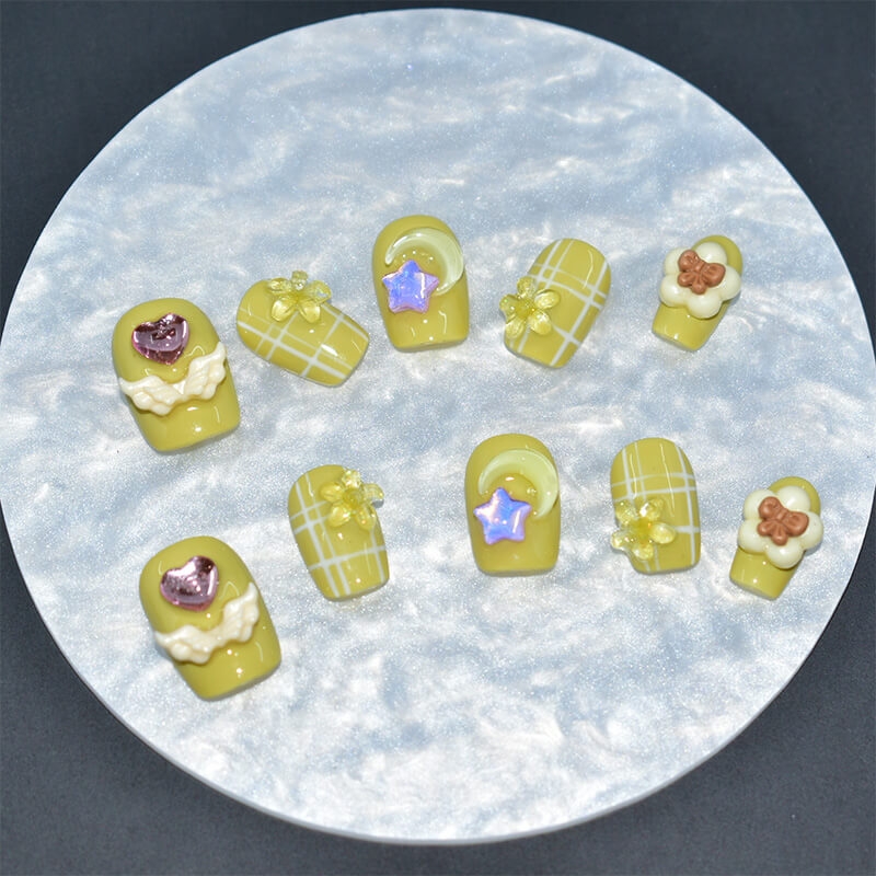square-shaped yellow press-on nails with white grid patterns, adorned with 3D flowers, stars, hearts, and moons