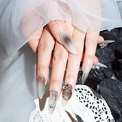 Close-up of brown ombre almond-shaped press-on nails with 3D embellishments, featuring a sophisticated and elegant look