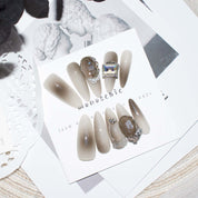 Set of brown ombre almond-shaped press-on nails with 3D pearls and rhinestones, offering a simple yet elegant look
