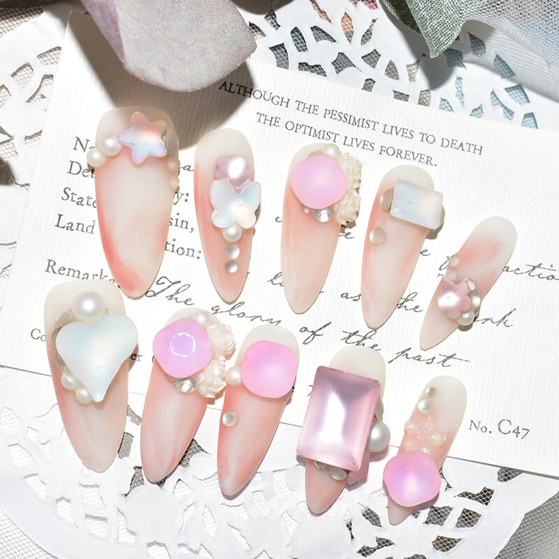 Set of pink candy matte press-on nails with 3D pearl and butterfly accents, displayed on a decorative card.