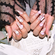 Hands showcasing pink candy matte press-on nails with charming 3D pearl and butterfly accents