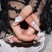 Detailed view of pink candy matte press-on nails with 3D pearl and butterfly accents, highlighting intricate designs
