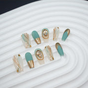 medicum Long, coffin-shaped press-on nails in matte aqua blue and glossy beige with gold accents