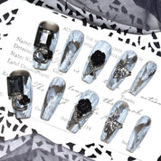 Set of Midnight Bloom on White Sands press-on nails displayed on a decorative card, highlighting the intricate 3D floral and chain designs