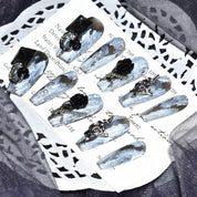 Elegant arrangement of Midnight Bloom on White Sands press-on nails, showcasing the white and black design with detailed 3D floral and chain accents
